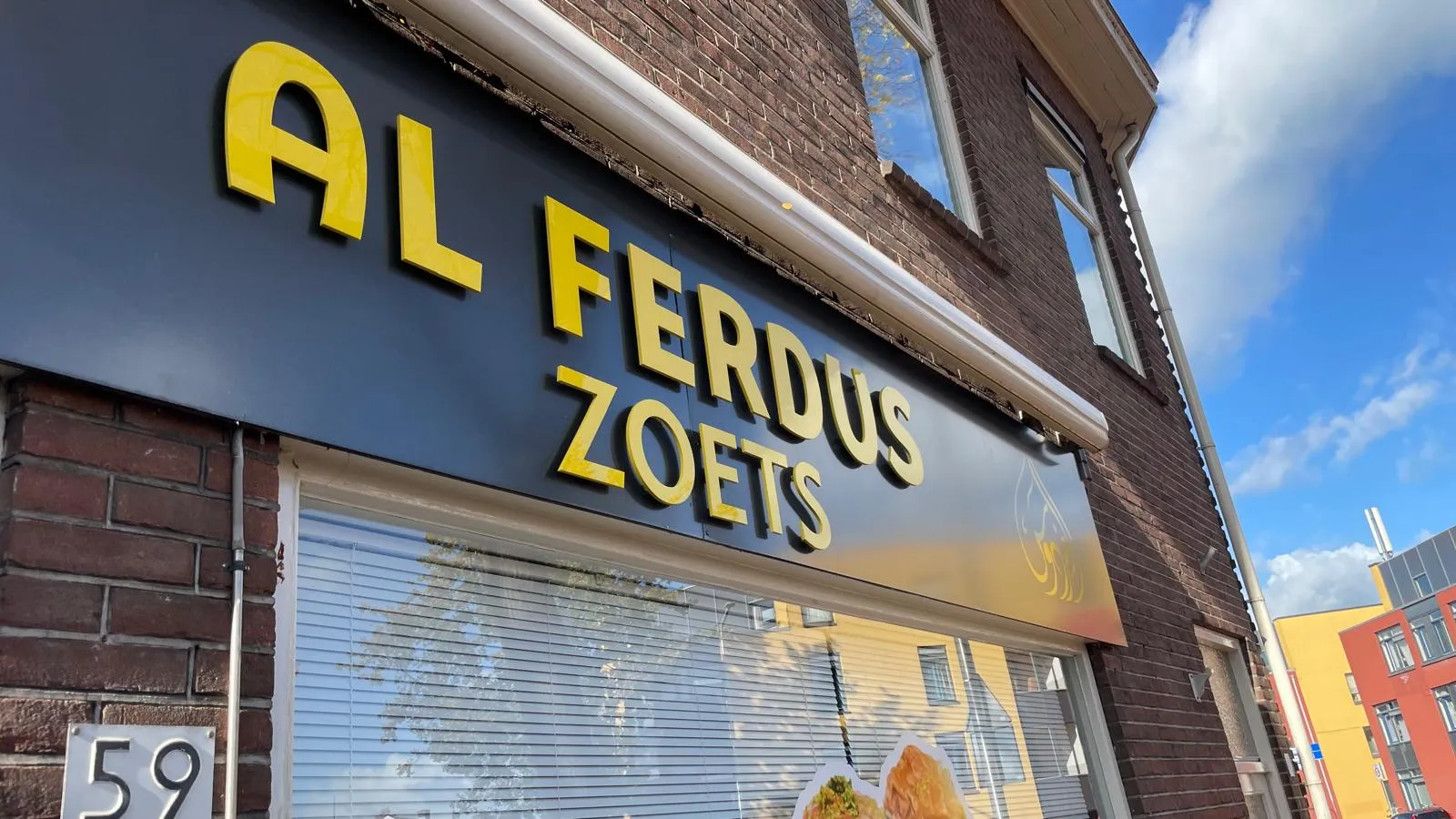 Gevelbelettering en verlichte lichtreclame voor Al Ferdus.