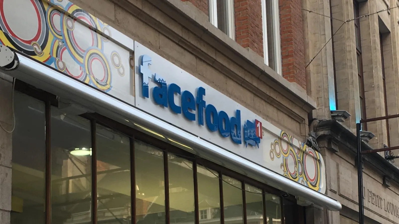 Gevelbelettering met blauwe lichtreclame voor eethuis Facefood.