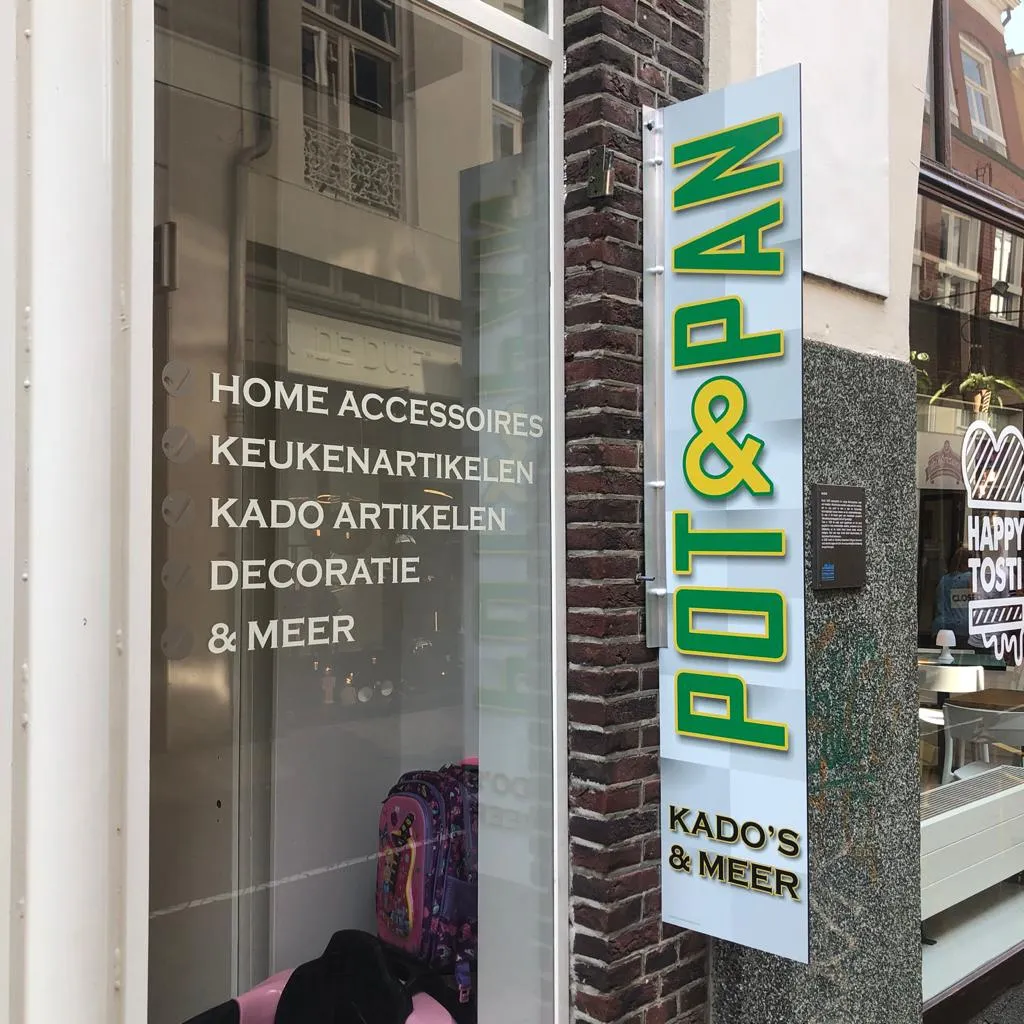 Matte raamfolie-belettering met productoverzicht en het Pot & Pan-logo op de etalageruit door ZON Reclame.