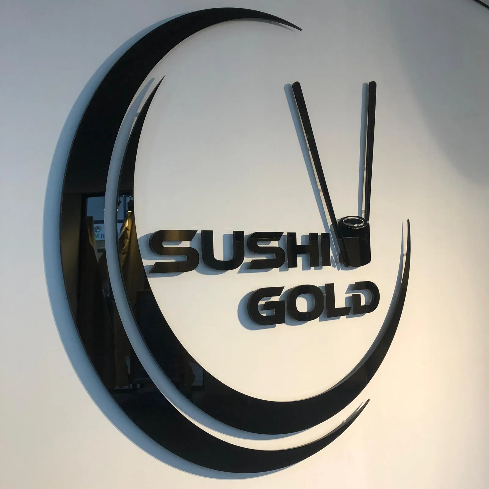 Zwarte 3D-acryl reliëfletters van het Sushi Gold-logo op de binnenmuur van het restaurant.